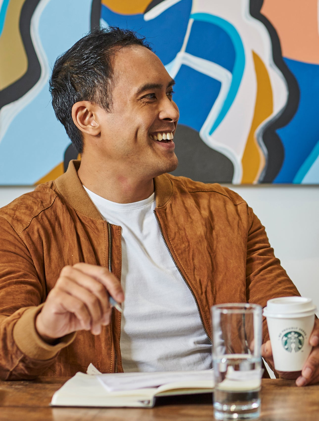幾位男士坐在桌旁，手裡拿著 We Proudly Serve Starbucks 星巴克咖啡服務字樣的咖啡